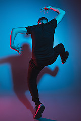 Image showing The silhouette of one hip hop male break dancer dancing on colorful background