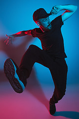 Image showing The silhouette of one hip hop male break dancer dancing on colorful background