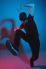 Image showing The silhouette of one hip hop male break dancer dancing on colorful background