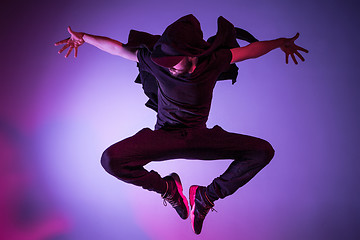 Image showing The silhouette of one hip hop male break dancer dancing on colorful background