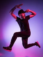 Image showing The silhouette of one hip hop male break dancer dancing on colorful background