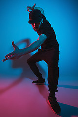 Image showing The silhouette of one hip hop male break dancer dancing on colorful background