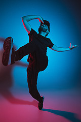 Image showing The silhouette of one hip hop male break dancer dancing on colorful background