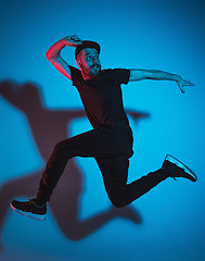 Image showing The silhouette of one hip hop male break dancer dancing on colorful background