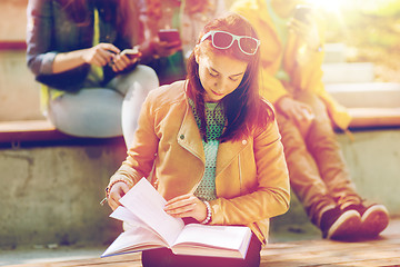 Image showing high school student girl reading book outdoors