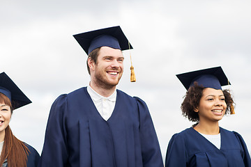 Image showing happy students or bachelors in mortar boards