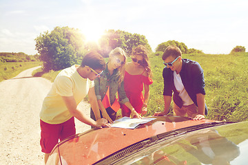 Image showing happy friends with map and car at country road