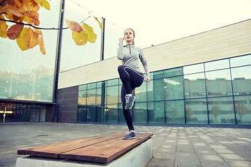 Image showing woman making step exercise on city street bench