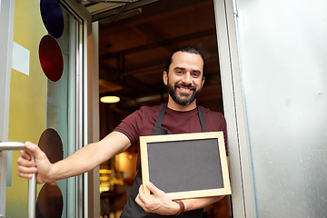 Image showing man or waiter with blackboard at bar entrance door