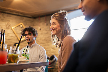 Image showing happy friends eating and drinking at restaurant