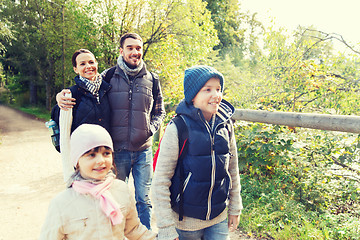 Image showing happy family with backpacks hiking in woods