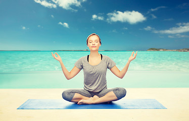 Image showing woman making yoga meditation in lotus pose on mat