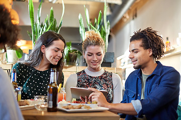 Image showing friends with tablet pc, drinks and food at bar