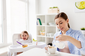 Image showing happy mother and baby having breakfast at home