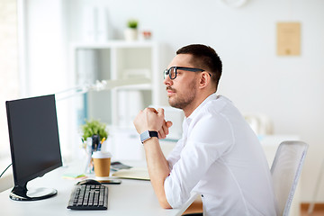 Image showing businessman in glasses sitting at office computer