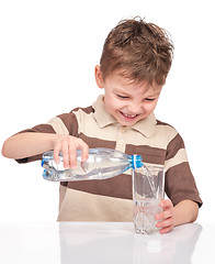 Image showing Boy with glass and plastic bottle of water