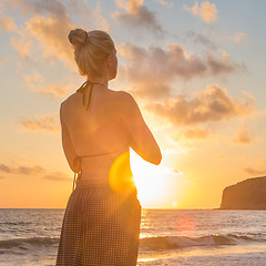 Image showing Woman practicing yoga on sea beach at sunset.