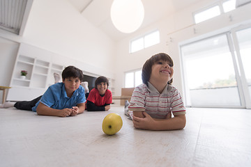 Image showing boys having fun with an apple on the floor