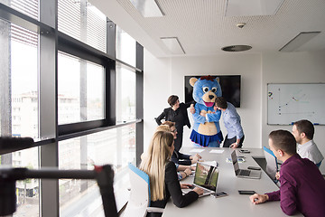 Image showing boss dresed as bear having fun with business people in trendy of