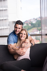 Image showing young handsome couple hugging on the sofa