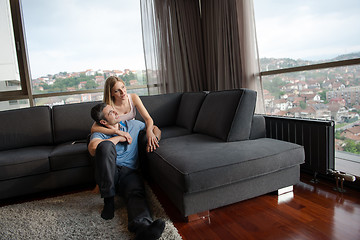 Image showing young handsome couple hugging on the sofa