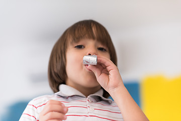 Image showing kid blowing a noisemaker