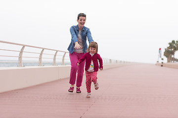 Image showing mother and cute little girl on the promenade by the sea