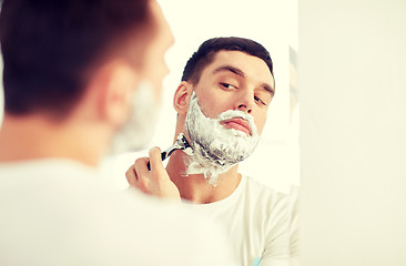 Image showing man shaving beard with razor blade at bathroom