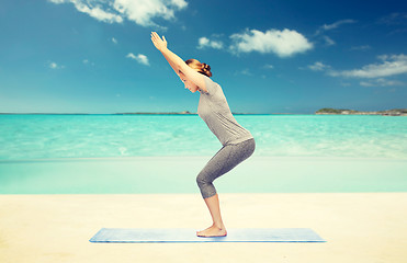 Image showing woman making yoga in chair pose on mat