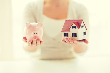 Image showing close up of woman with house model and piggy bank