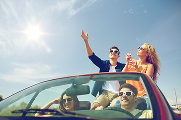 Image showing friends driving in car and blowing bubbles