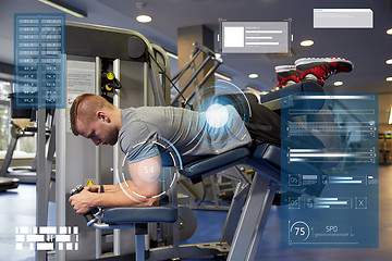 Image showing man flexing leg muscles on gym machine