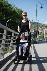 Image showing mother pushed her baby daughter in a stroller