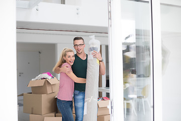 Image showing couple carrying a carpet moving in to new home