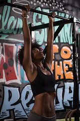 Image showing black woman doing pull ups