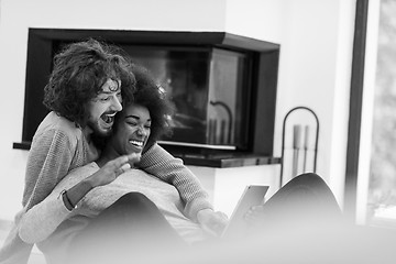 Image showing multiethnic couple used tablet computer on the floor