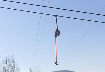 Image showing Snowboarder using a surface lift on the slope.