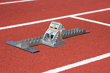 Image showing Athletics starting blocks on race red track