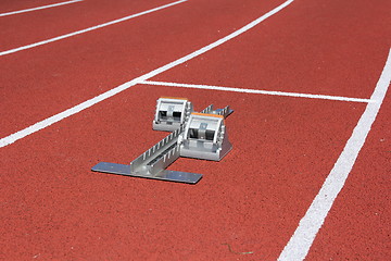 Image showing Athletics starting blocks on race red track