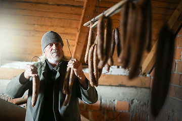 Image showing Man drying sausages