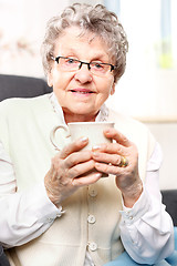 Image showing The old lady drinking a brew of herbs Grandma's first aid kit, an infusion of herbs.