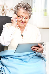 Image showing Older woman with a tablet. Retired, entertainment on the Internet University of the Third Age.