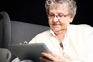 Image showing Older woman with a tablet. Retired, entertainment on the Internet