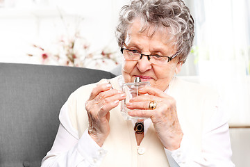 Image showing Mature well groomed woman perfumes to expensive perfumes.