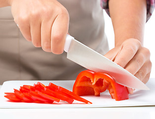 Image showing Cook is chopping bell pepper