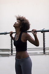 Image showing black woman lifting empty bar