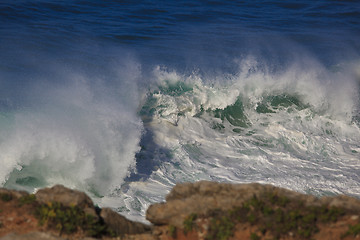 Image showing Marine wave breaks against offshore stone