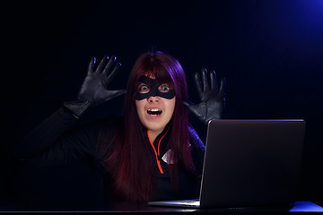 Image showing Brunette hacker with raised hands