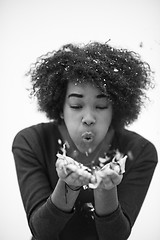 Image showing African American woman blowing confetti in the air