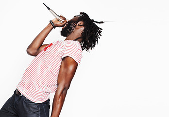 Image showing young handsome african american boy singing emotional with microphone isolated on white background, in motion gesturing smiling, lifestyle people concept 